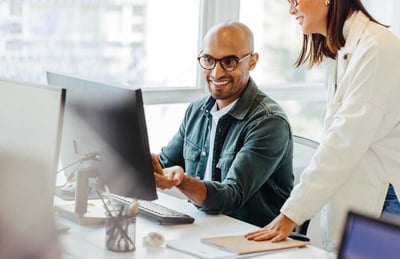 Coworkers Smiling Looking at Screen Coworkers Smiling Looking at Screen