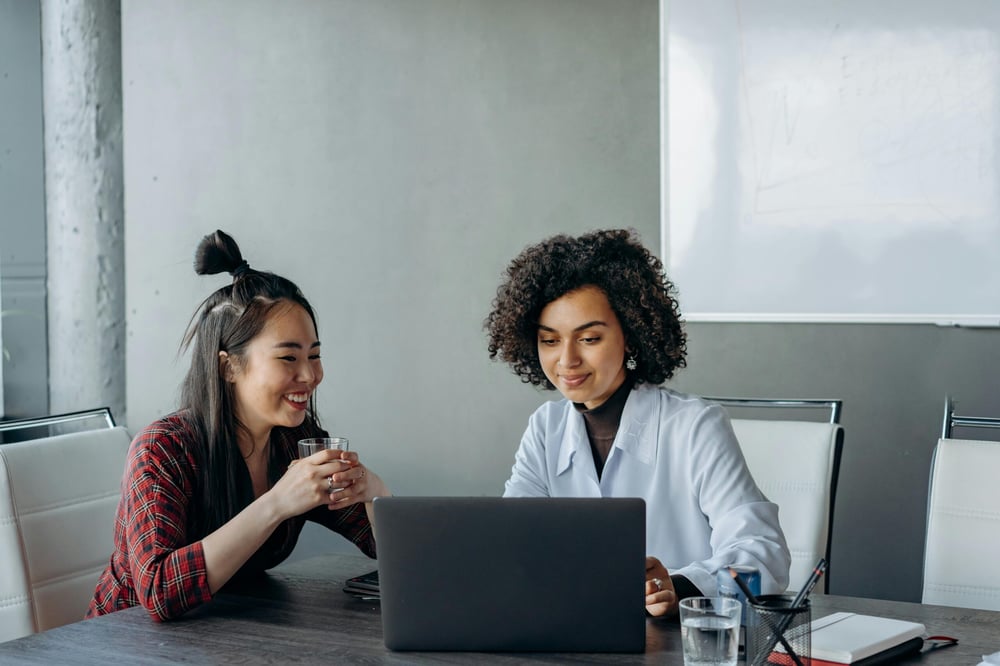 Two women working together at a laptop